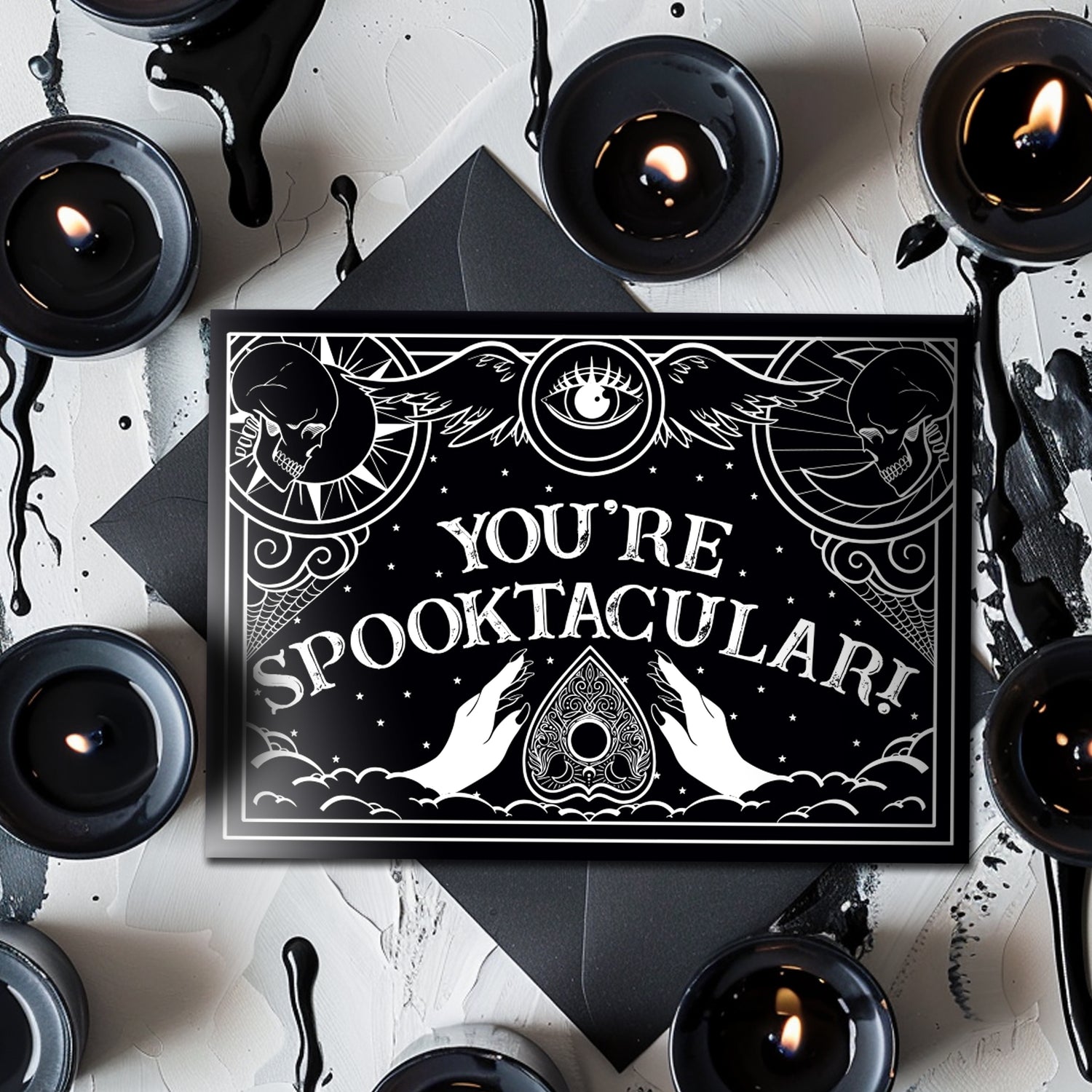 Gothic greeting card with black and white Ouija board design and spooky lettering that reads “Have a Spooktacular Day,” perfect for any eerie occasion.