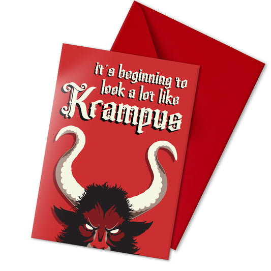 A5 glossy portrait Christmas card on red with large Krampus horns and eyes, cream gothic lettering reading “it’s beginning to look a lot like Krampus”. Small printed Krampus silhouette inside corner. Includes red envelope. Blank area for message.