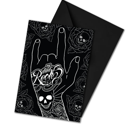Glossy black Father’s Day card featuring a hand throwing the rock horns with skull and rose tattoos, and the phrase “My Dad Rocks” in ink lettering.