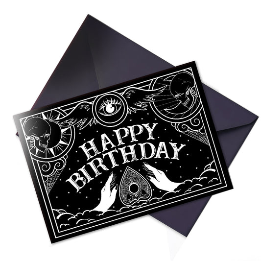 A large glossy birthday card with black and white Ouija board design and spooky lettering that reads “Have a Spooktacular Birthday,” with ornate planchette details.