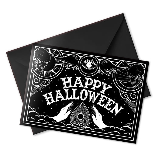 A black glossy A5 Halloween card with a white Ouija board-inspired “Happy Halloween” design, styled with gothic props on a dark background.