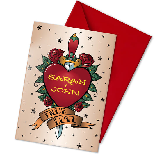 A personalised couples greeting card inspired by traditional tattoo designs. A red heart with an ornate handled dagger vertically through it, is surrounded by roses and stars. Underneath it, a banner reads "true love" in traditional tattoo text. the custom gold foiled text inside the heart reads the couple's names. Inside another similar banner reads "forever". Perfect for wedding guests, anniversary or valentines.