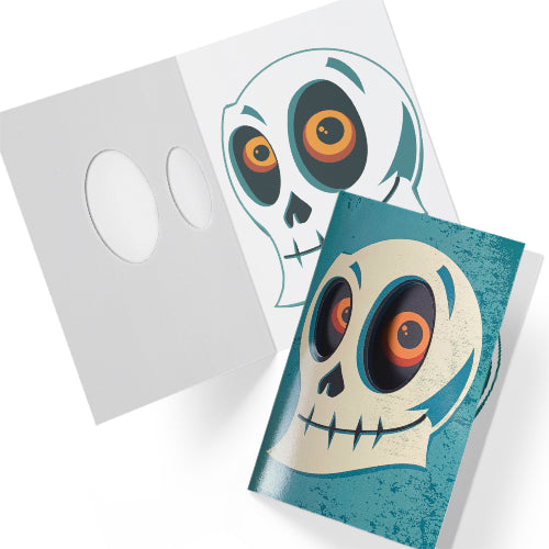 A glossy blue A5 Halloween card with a skull design, featuring cut-out eyes that reveal an eerie gaze inside, styled with gothic Halloween props.