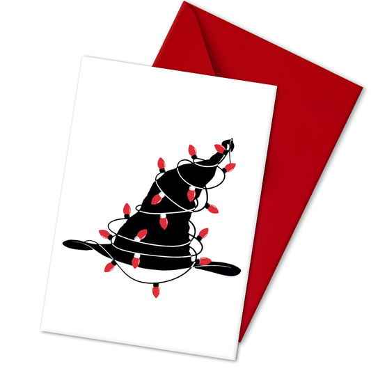 A5 glossy portrait Christmas card with minimalist black witch hat wrapped in red string lights on a white background. Clean graphic style. Includes red envelope. Blank inside.