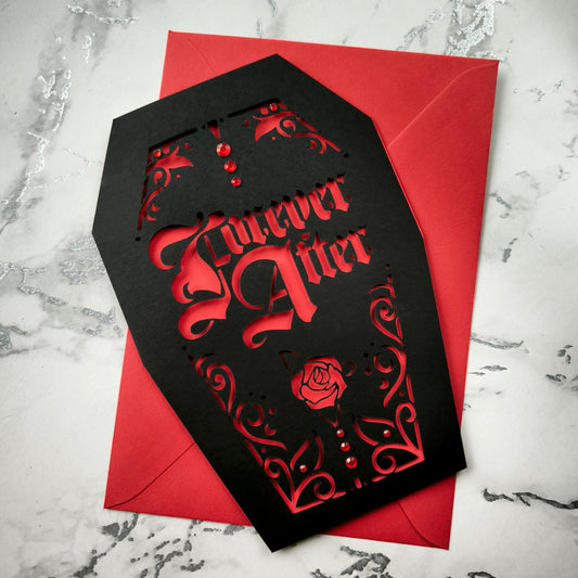 A handmade black coffin-shaped card with an intricate gothic-style design cut out to reveal a res interior. The words 'Forever After' are cut from the centre, and accentuated with subtle red gems like drops of blood. Vampire vibes for horror fans and lovers of the macabre.