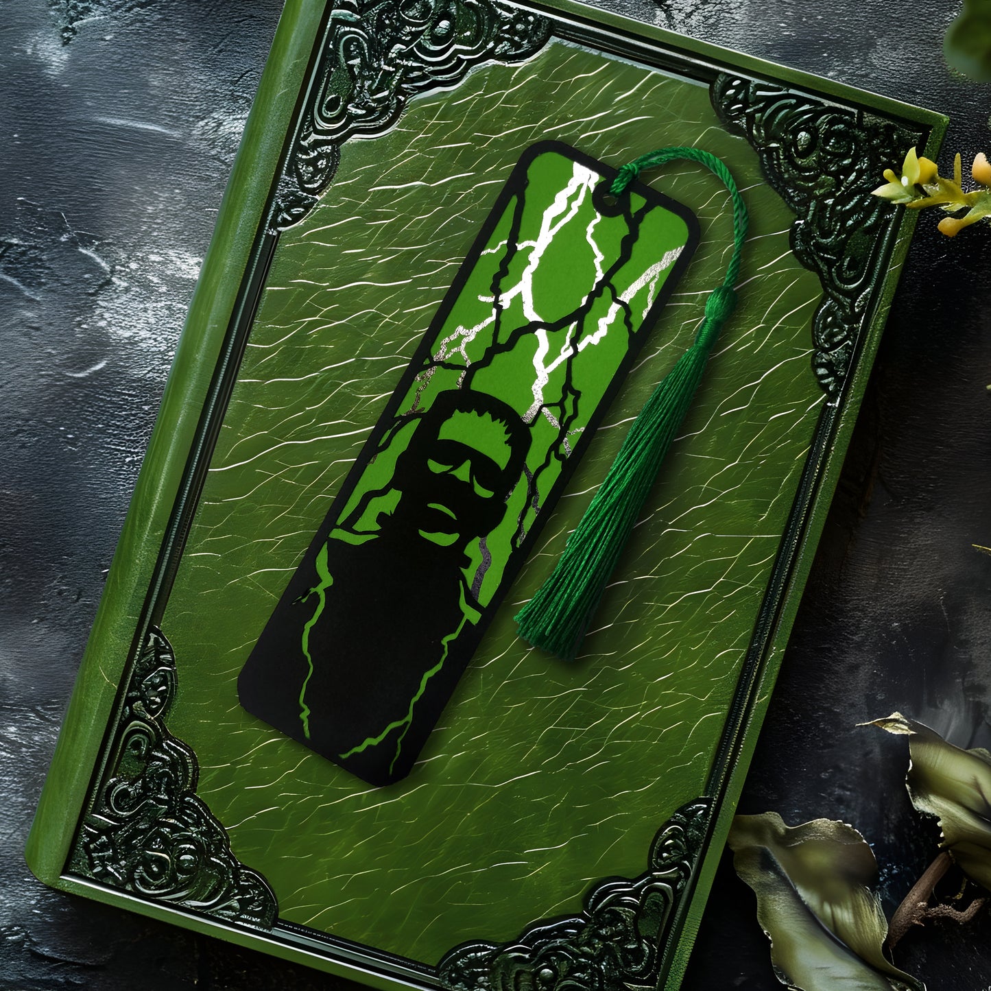 Gothic black bookmark featuring the silhouette of frankenstein's monster over a green background and silver metallic lightning strikes. Finished with a matching tassel. Perfect for horror and classic literature fans.
