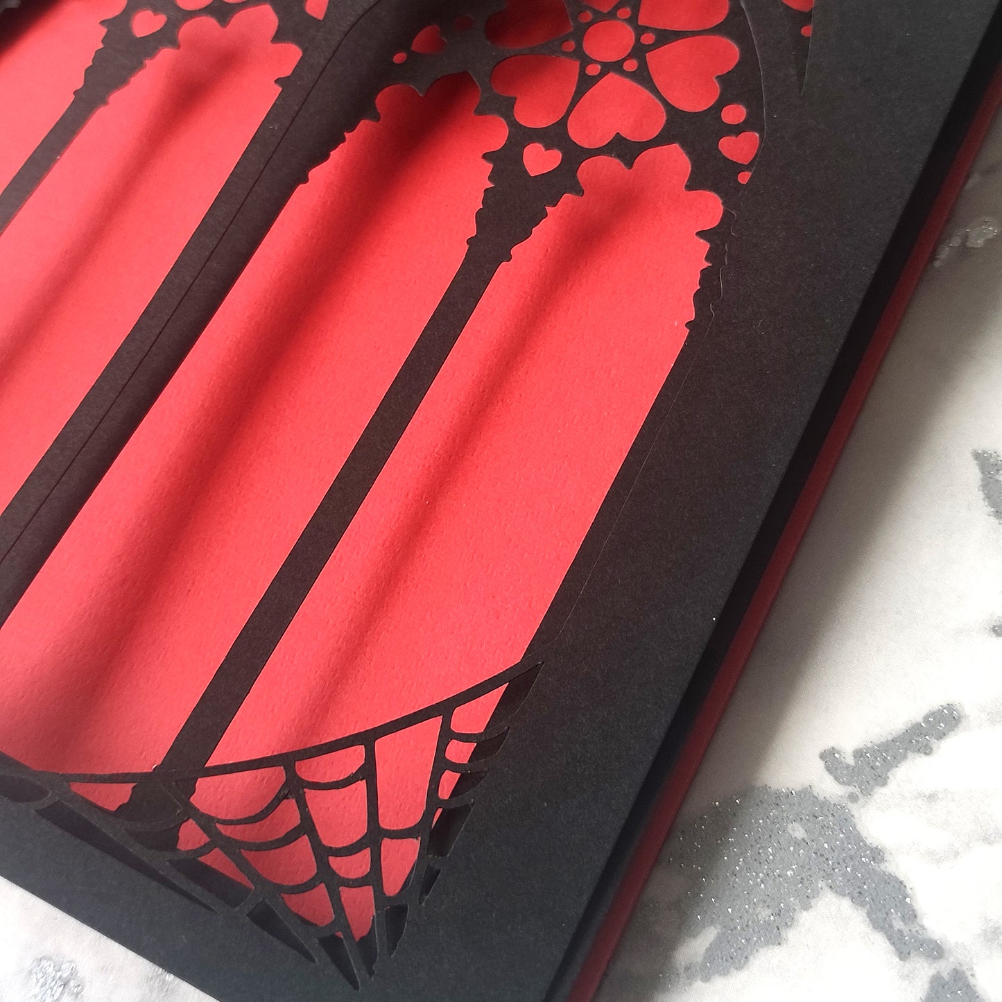 Handmade A5 black greeting card with layered gothic arch design and red heart cut-out revealing soft pink interior. Blank inside with envelope included. Perfect for gothic weddings, anniversaries, or alternative Valentine’s Day.