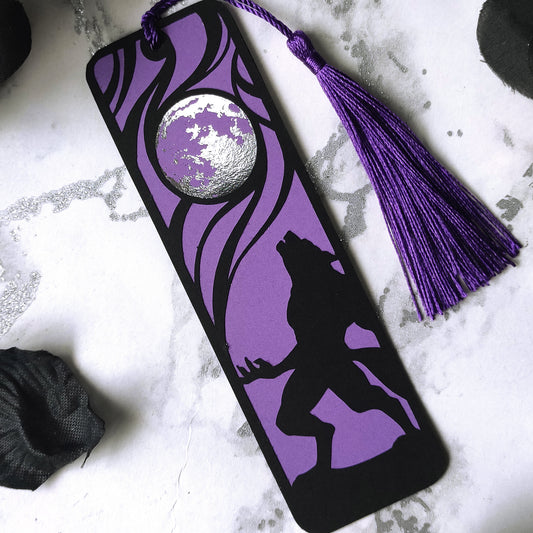 Classic horror werewolf bookmark featuring a black werewolf silhouette against a purple background and metalllic silver full moon, with matching tassel, perfect for gothic readers.