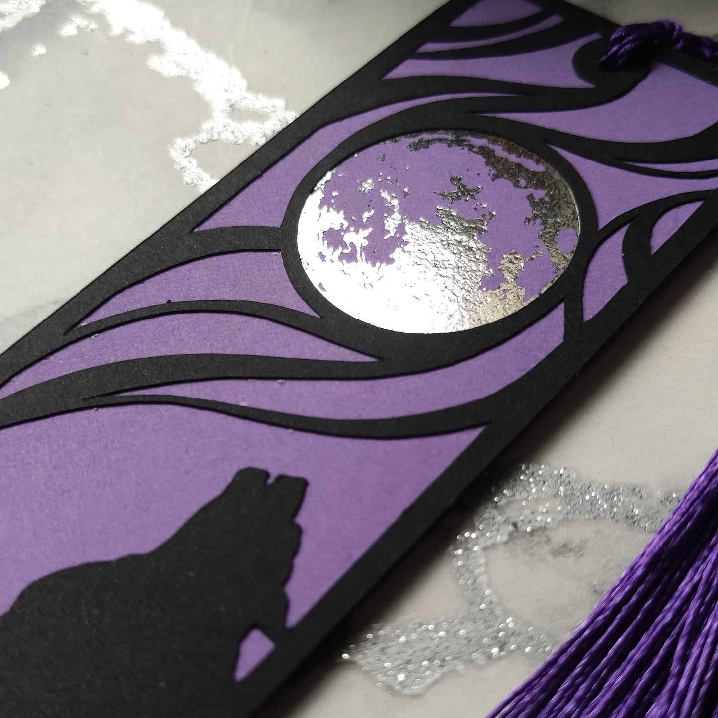Classic horror werewolf bookmark featuring a black werewolf silhouette against a purple background and metalllic silver full moon, with matching tassel, perfect for gothic readers.