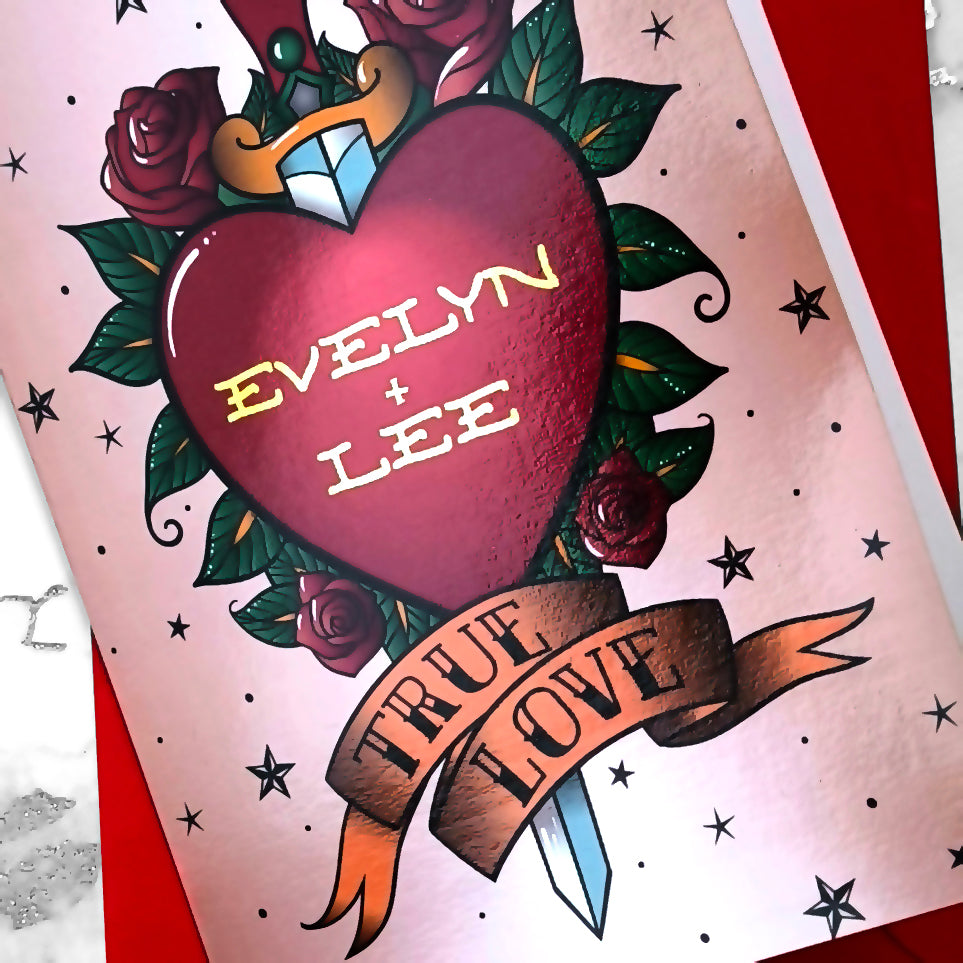 Tattoo-style personalised greeting card with gold foil names on a red heart, dagger, roses, and “True Love” banner. Vintage sailor design with red envelope.