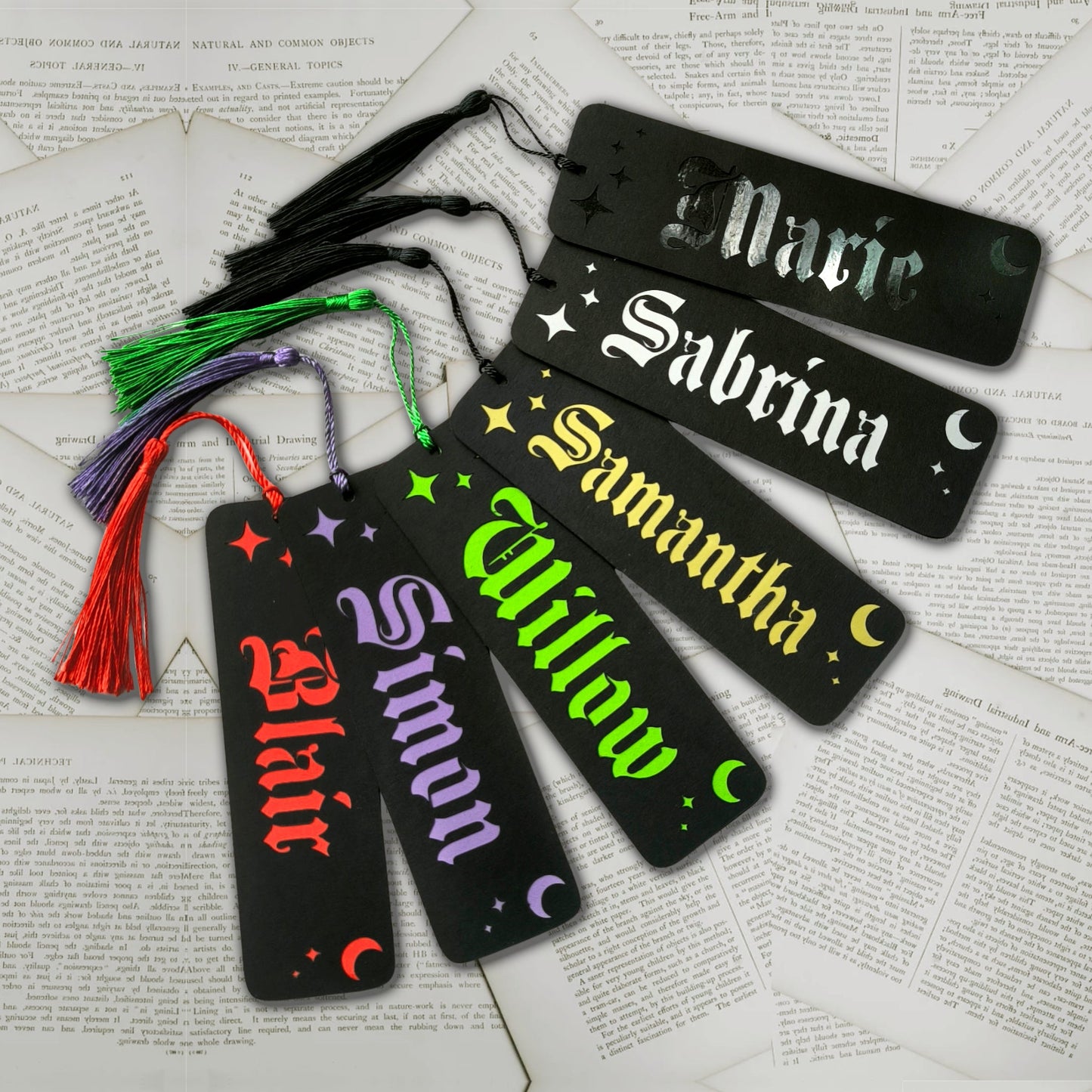 Handmade personalised bookmarks in a variety of colours and metallics. Names cut from black card to reveal the chosen shade underneath, surrounded by moons and stars, with similar celestial papercut designs in the back.