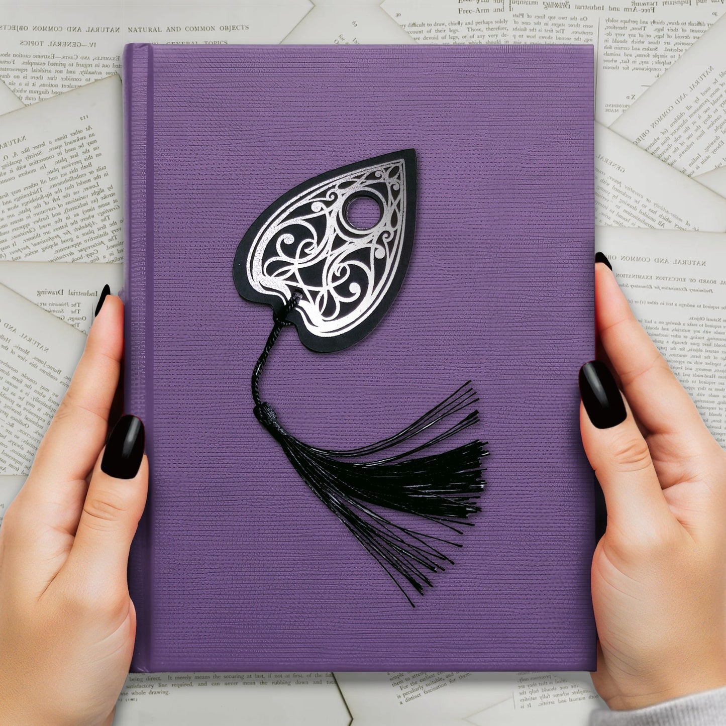 Handmade Gothic Ouija planchette bookmark with intricate silver metallic detailing and a black tassel, perfect for witchy, spooky, and alternative book lovers.