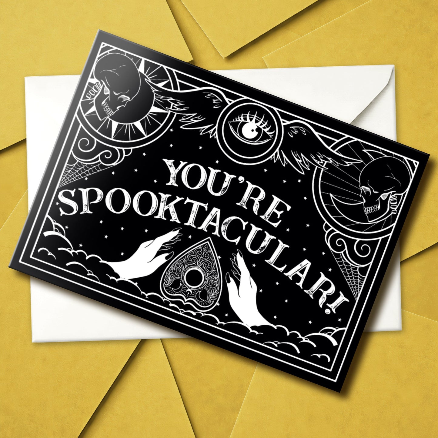 Gothic greeting card with black and white Ouija board design and spooky lettering that reads “Have a Spooktacular Day,” perfect for any eerie occasion.