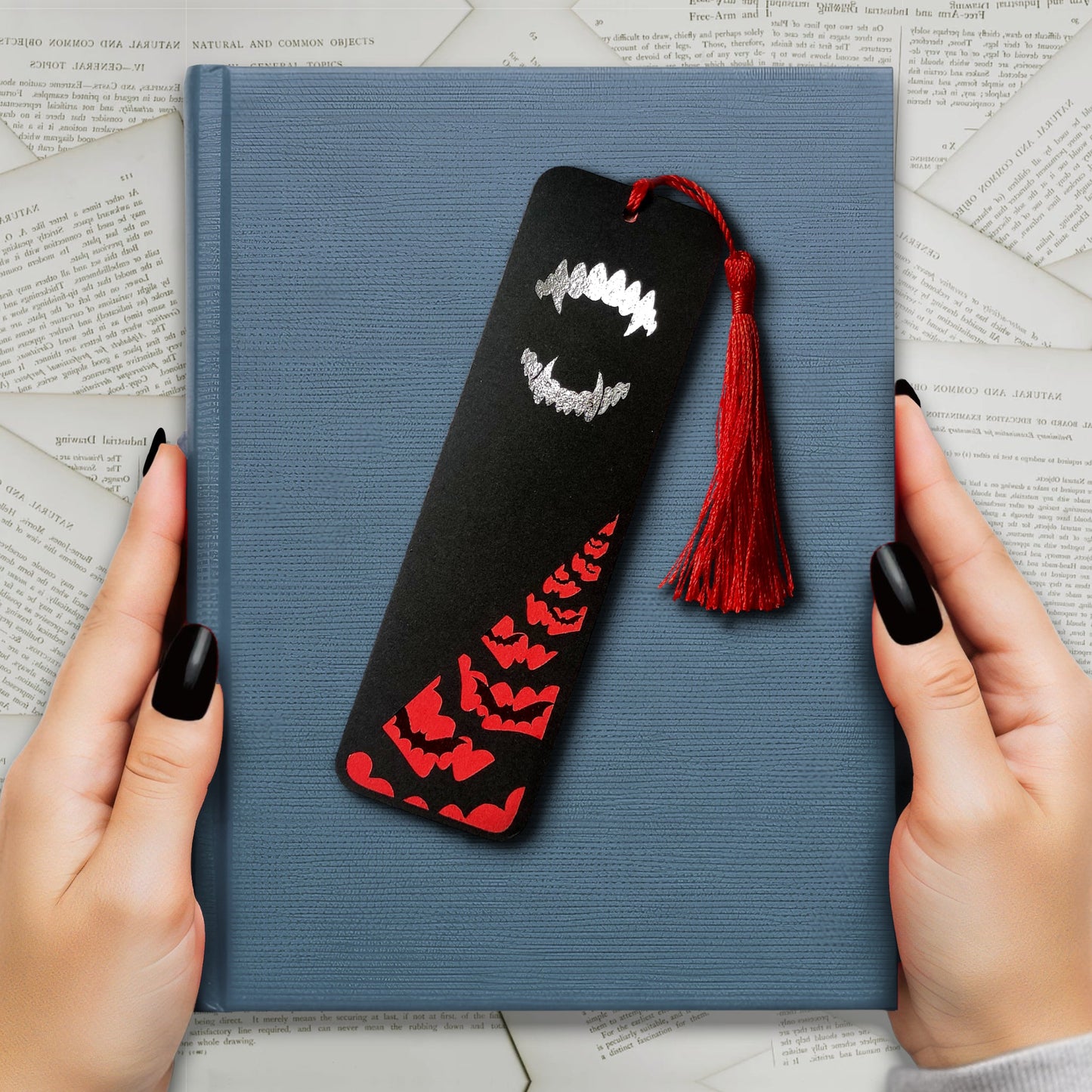 Gothic Dracula bookmark with silver metallic fangs and a flock of black foil bats flying across a deep red background. Finished with a matching tassel. Perfect for fans of vampires, classic horror, and dark, alternative literature.
