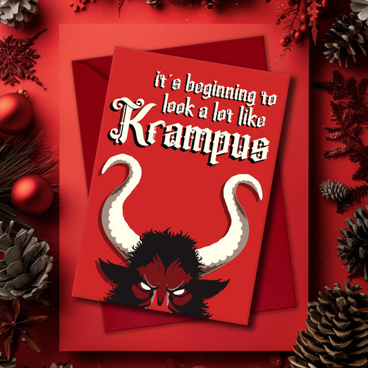 A5 glossy portrait Christmas card on red with large Krampus horns and eyes, cream gothic lettering reading “it’s beginning to look a lot like Krampus”. Small printed Krampus silhouette inside corner. Includes red envelope. Blank area for message.