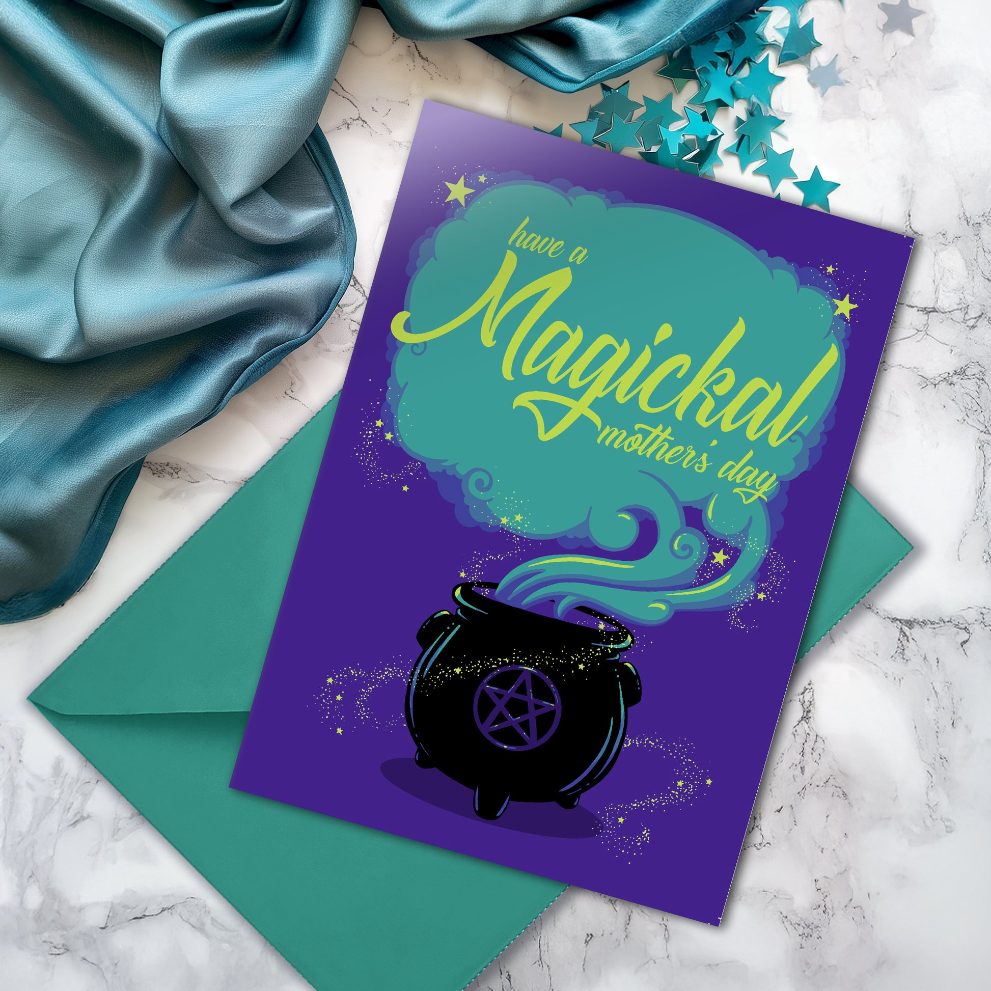 A large A5 greeting card in purple or pink, featuring a witchy cauldron illustration with billowing sparkling clouds and the words "Have a Magickal Mother’s Day." The inside has an illustration only (no text). Comes with an envelope included.
