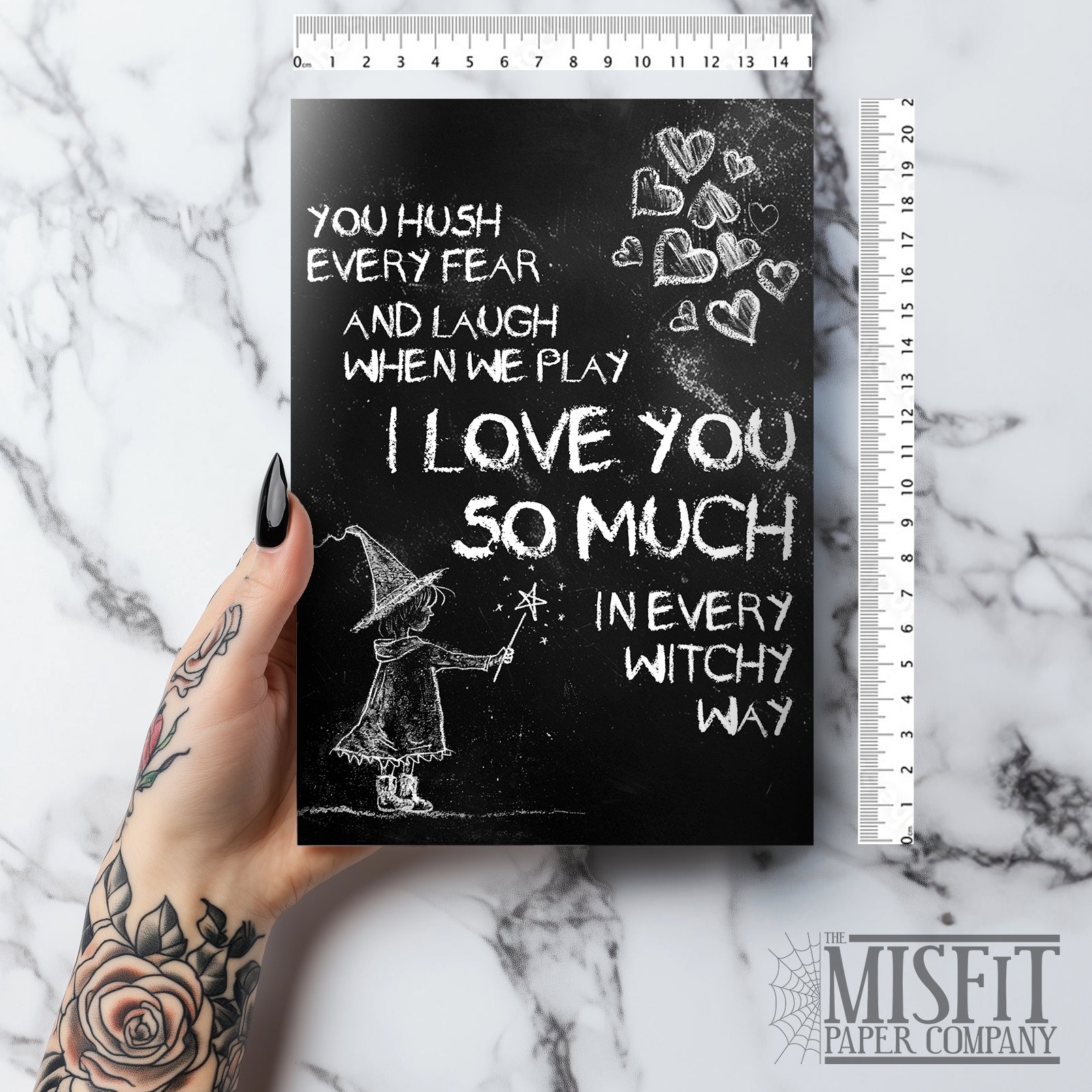 A black A5 greeting card with a chalkboard-style background, featuring a hand-drawn witch illustration casting a spell with floating love hearts. A sweet rhyming poem is written in chalk-style lettering. The card reads Happy Mother's Day inside and comes with an envelope.