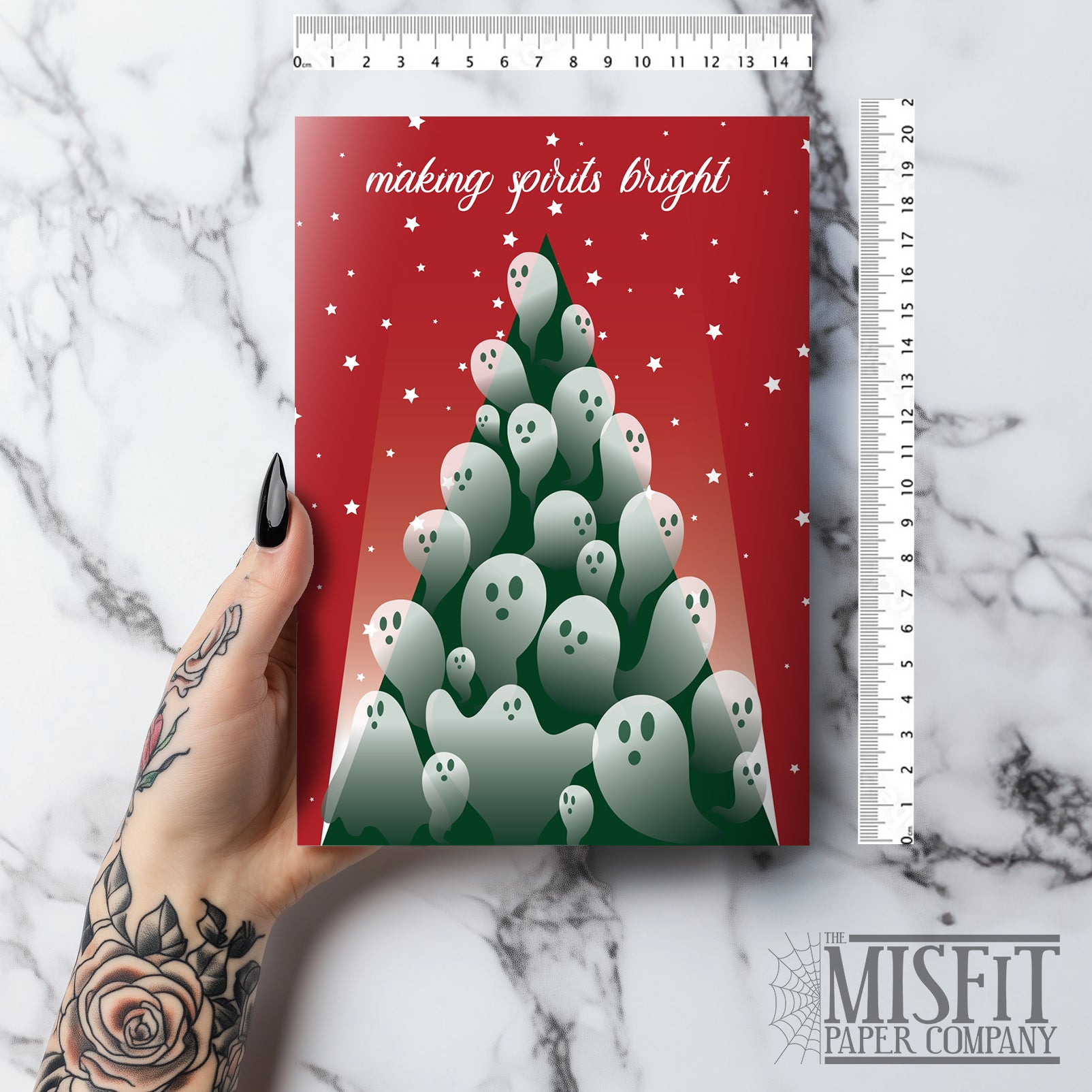 A5 glossy portrait Christmas card with red background and starry sky. Green tree flooded with semi-transparent ghosts, white script text “making spirits bright”. Small ghost and stars print inside. Includes red envelope. Blank area for message.