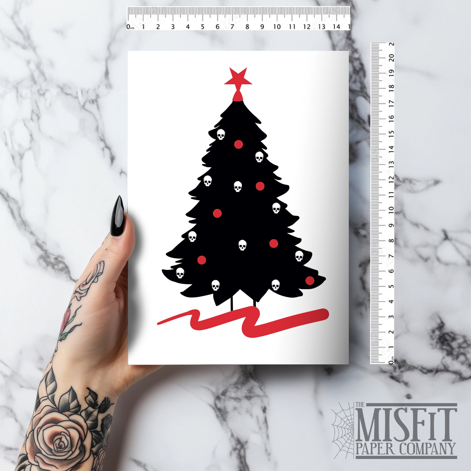 A5 glossy portrait Christmas card on white with black tree silhouette decorated with small skull baubles and a red pentacle star topper, red sweep at base. Includes red envelope. Blank inside.