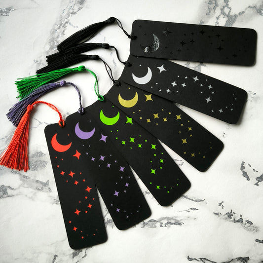 Custom gothic bookmarks with cutout names and celestial moon and star designs in red, purple, green, gold, and silver, with matching tassels