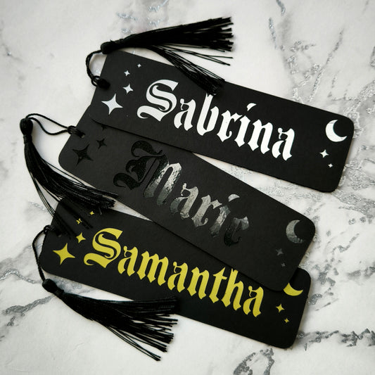 Custom gothic bookmarks with cutout names and celestial moon and star designs in red, purple, green, gold, and silver, with matching tassels