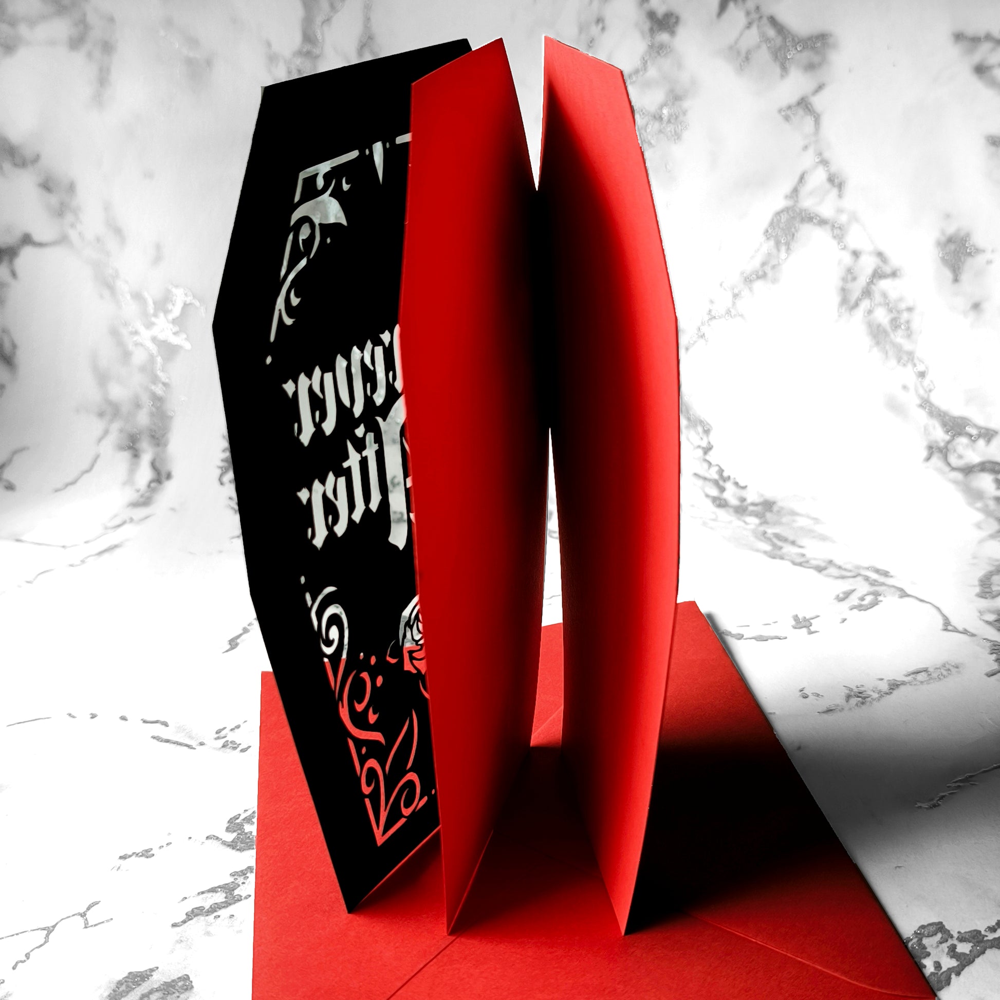 Intricately cut from rich black card with blood-red backing, this dramatic design features a blooming red rose and sparkling red gems for a touch of macabre glamour.
