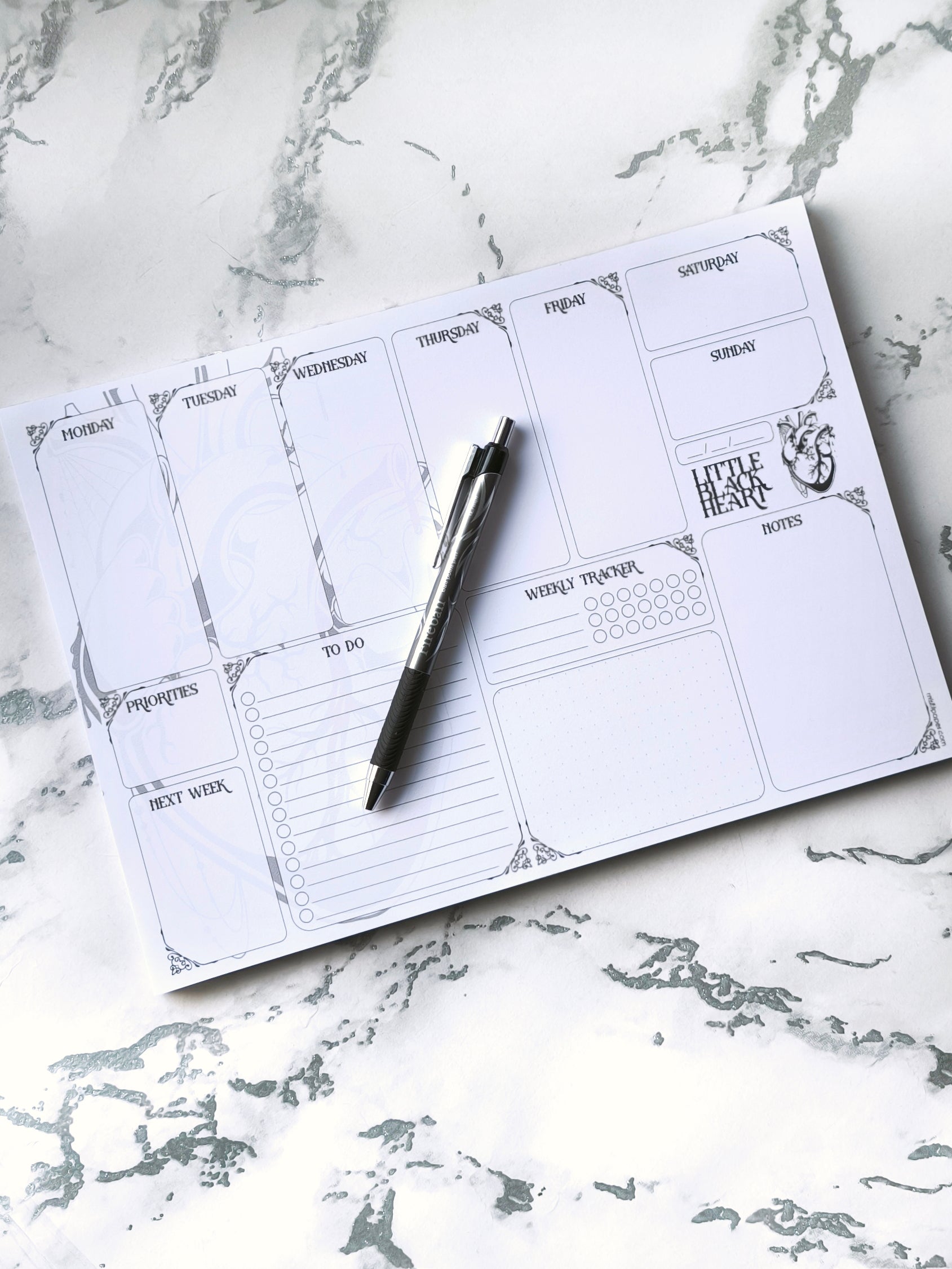 A4 undated weekly planner pad with gothic headings. Large daily boxes, to-do list, notes area, dotted section and habit tracker circles. Monochrome layout on smooth tear-off desk pad.
