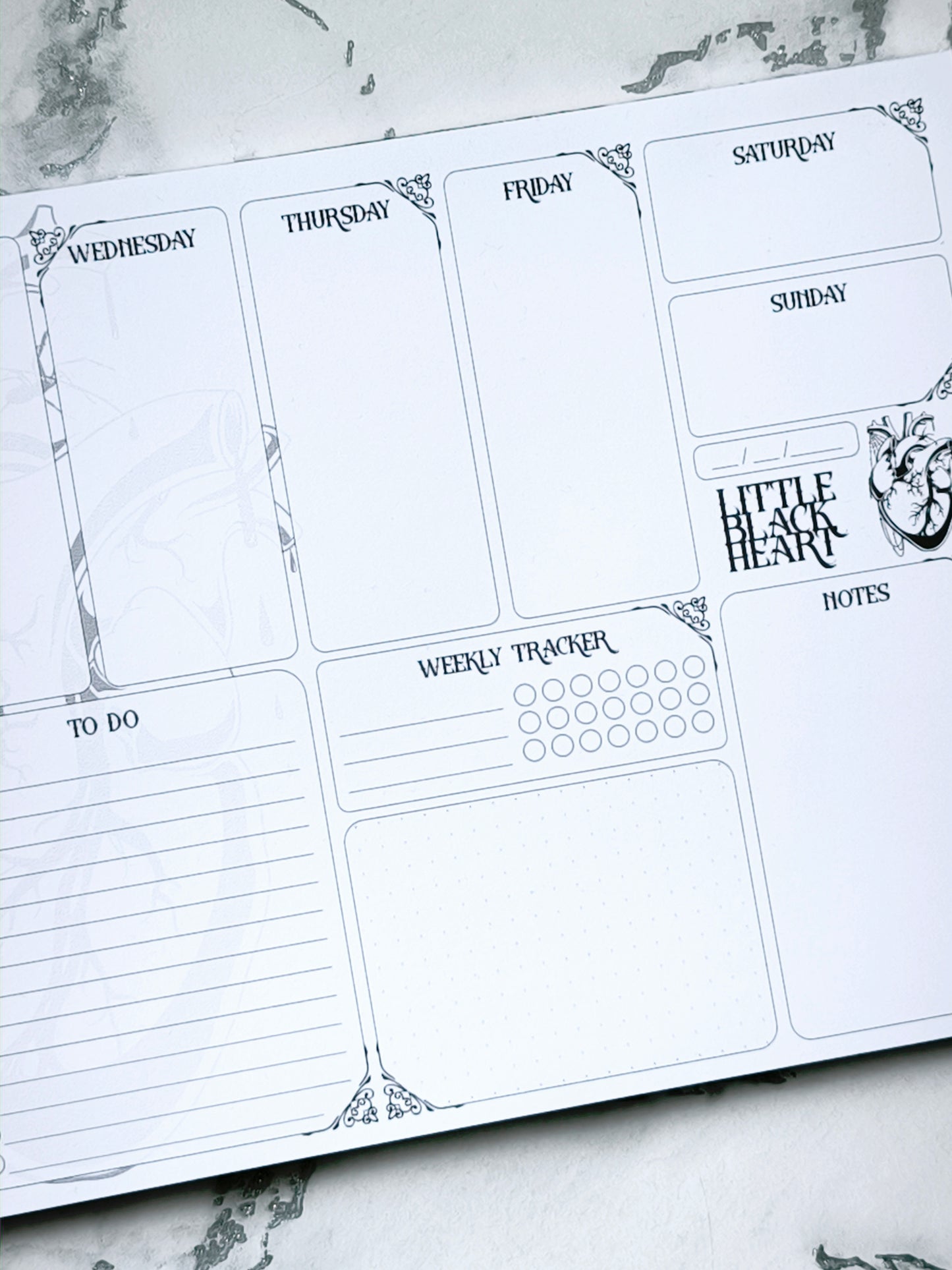 A4 undated weekly planner pad with gothic headings. Large daily boxes, to-do list, notes area, dotted section and habit tracker circles. Monochrome layout on smooth tear-off desk pad.