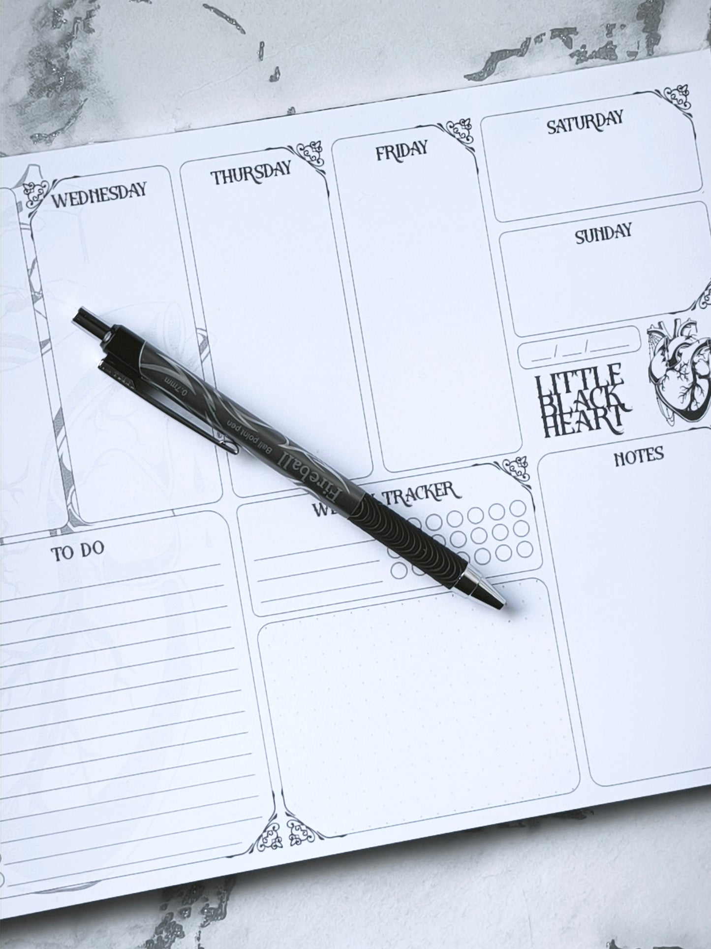A4 undated weekly planner pad with gothic headings. Large daily boxes, to-do list, notes area, dotted section and habit tracker circles. Monochrome layout on smooth tear-off desk pad.