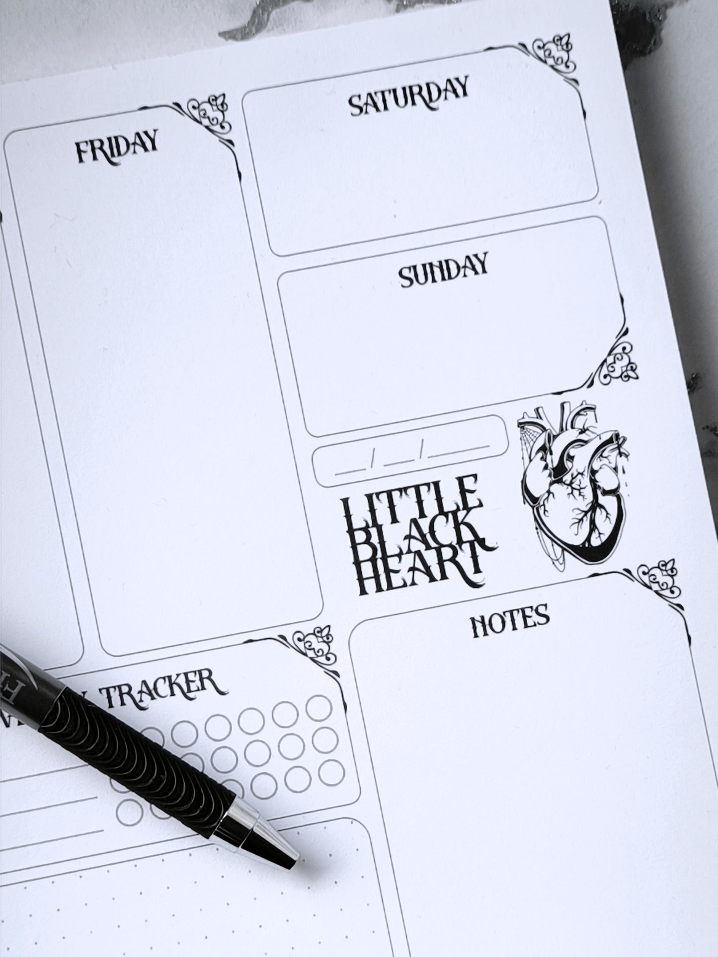 A4 undated weekly planner pad with gothic headings. Large daily boxes, to-do list, notes area, dotted section and habit tracker circles. Monochrome layout on smooth tear-off desk pad.