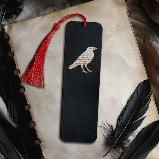 Handmade bookmark inspired by Edgar Allan Poe's poem The Raven. A raven shape cut from on each side of black card reveals a yellowed and aged section of text from the iconic horror classic, and is finished off with a silky red tassel.