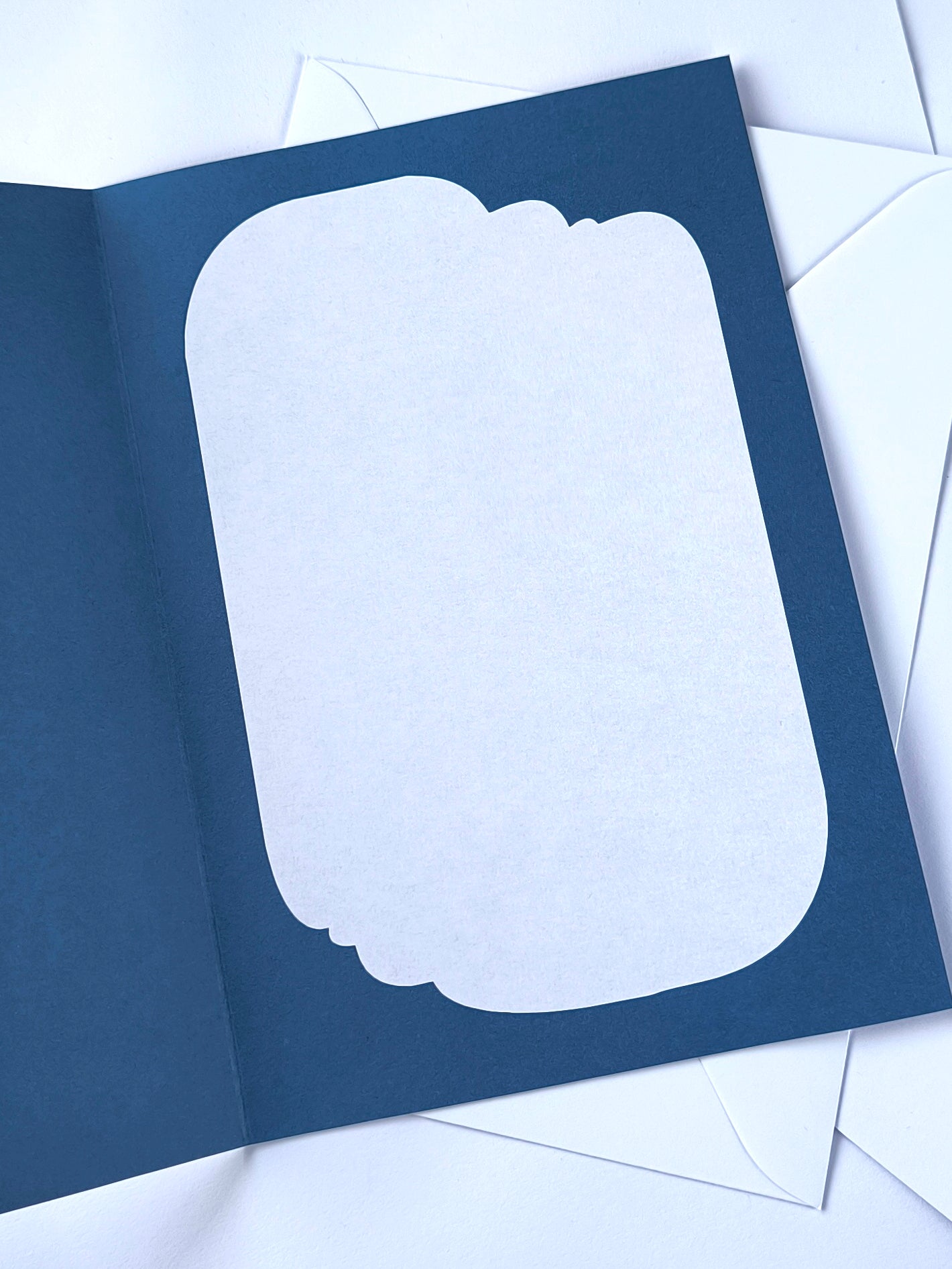 Handmade A5 layered papercut new baby card in deep navy with a cream crescent moon, white cloud layers, and silver foil star details, personalised with the phrase "welcome baby" and a custom name in silver foil script. The navy interior has a blank white cloud for your own message.