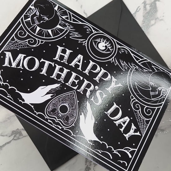 Gothic Mother’s Day card with black and white Ouija board design and ornate planchette details, blank inside with illustrated interior and matching envelope.