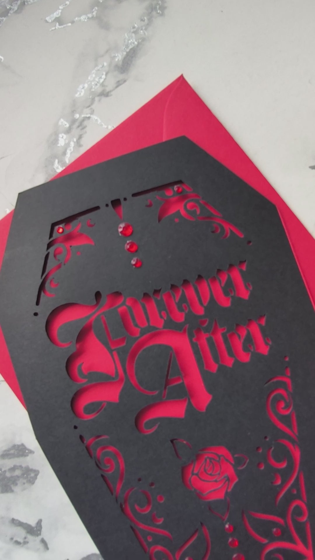 Intricately cut from rich black card with blood-red backing, this dramatic design features a blooming red rose and sparkling red gems for a touch of macabre glamour.