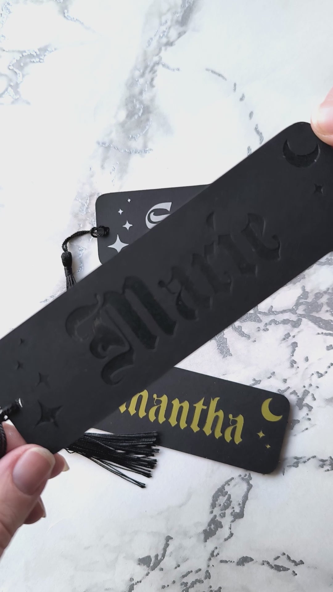 Custom gothic bookmarks with cutout names and celestial moon and star designs in red, purple, green, gold, and silver, with matching tassels